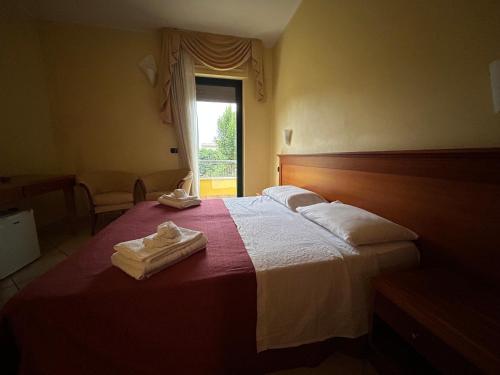 a hotel room with a bed with towels on it at Costa Doro - Ristorante Hotel in Salve