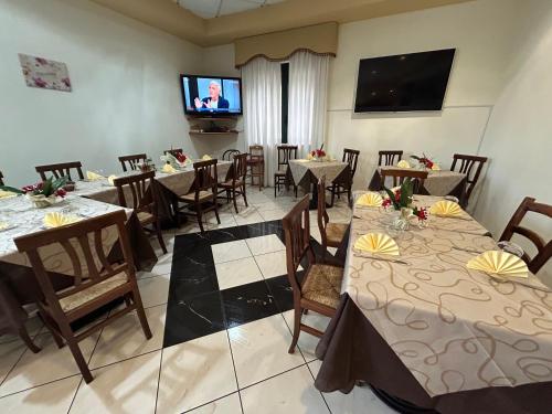 a dining room with tables and chairs and a flat screen tv at Costa Doro - Ristorante Hotel in Salve