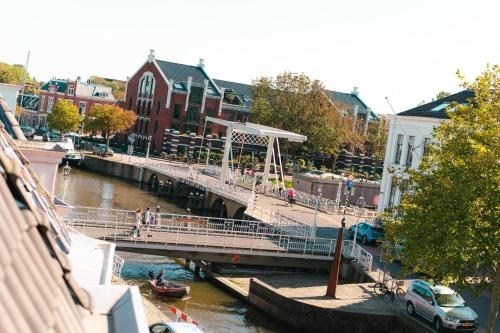 a bridge over a river with people walking on it at Hotel Restaurant 't Heerenlogement in Harlingen