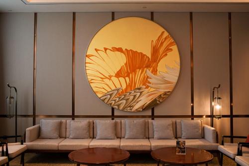 a living room with a couch and a large mirror at Holiday Inn Fuyang by IHG in Fuyang