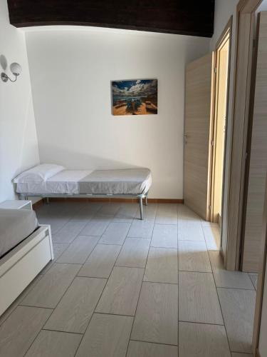 a bedroom with a bed and a wooden floor at Le Saline Rooms Marzamemi in Marzamemi