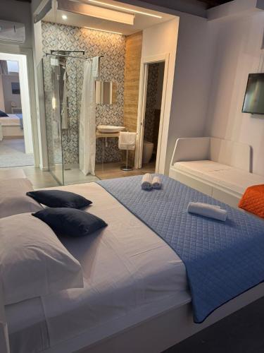 a bedroom with a large bed and a bathroom at Le Saline Rooms Marzamemi in Marzamemi