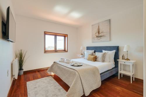 a bedroom with a bed and a table in it at Beach Villa with Jacuzzi & Garage by HostWise in Vila Chã