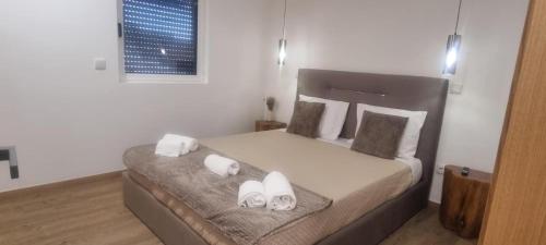 una camera da letto con un letto con due asciugamani sopra di Serração House - Gerês a Rio Caldo
