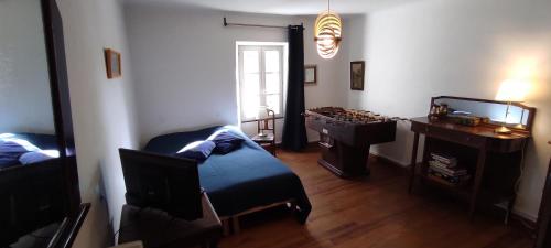 a living room with a table and a chair and a chessboard at Le Mas in Entrechaux