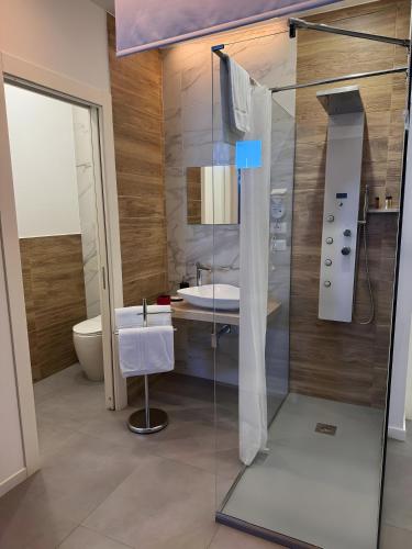 a bathroom with a glass shower and a sink at Le Saline Rooms Marzamemi in Marzamemi