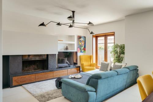 a living room with a blue couch and a fireplace at Beach Villa with Jacuzzi & Garage by HostWise in Vila Chã