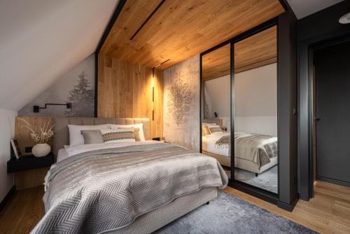 a bedroom with two beds and a large window at Osada Gubałówka na Polanie Pająkówka & SPA in Kościelisko