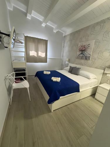 a bedroom with a large bed and a ladder at Le Saline Rooms Marzamemi in Marzamemi