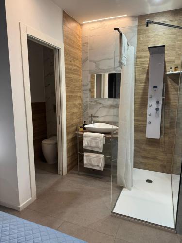 a bathroom with a glass shower and a sink at Le Saline Rooms Marzamemi in Marzamemi