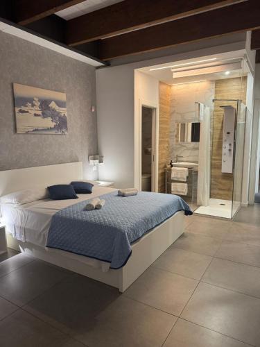 a bedroom with a large bed and a bathroom at Le Saline Rooms Marzamemi in Marzamemi