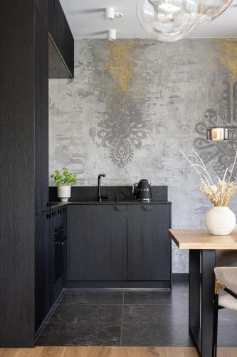 a kitchen with black cabinets and a wall with graffiti at Osada Gubałówka na Polanie Pająkówka & SPA in Kościelisko