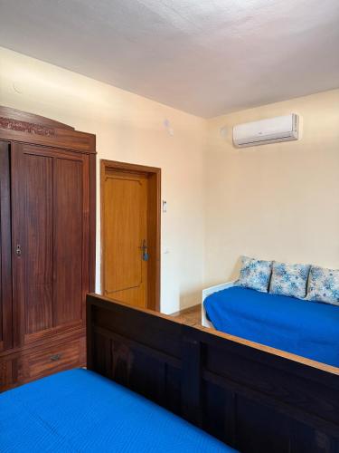 a bedroom with a blue bed and a wooden cabinet at Apartment Celeste - Isola D'elba in San Giovanni