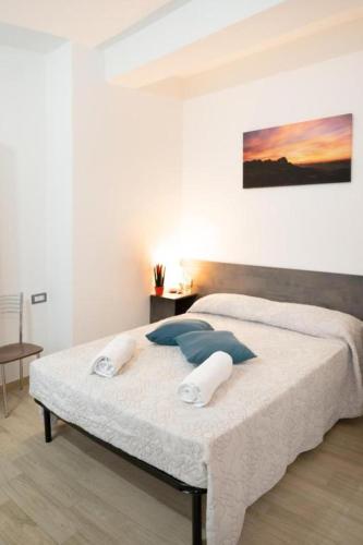 a bedroom with a large white bed with blue pillows at Affittacamere Da Riccardo in Jerzu