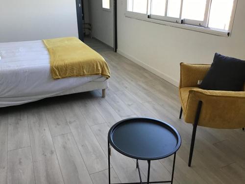 a bedroom with a bed and a chair and a table at Appartement face à la mer 2 in Port-la-Nouvelle