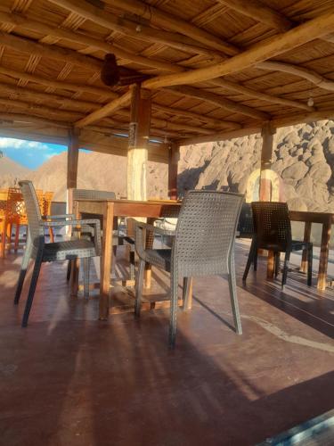 a table and chairs on a patio with mountains in the background at maison isabel in Boumalne