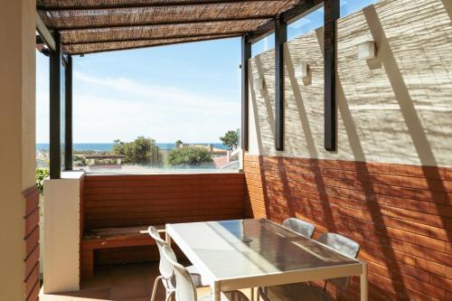 a table and chairs on a balcony with a view of the ocean at Beach Villa with Jacuzzi & Garage by HostWise in Vila Chã