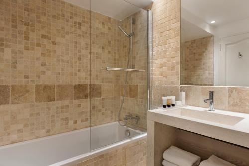 a bathroom with a tub and a sink and a shower at Le Fregate Provence in Bandol