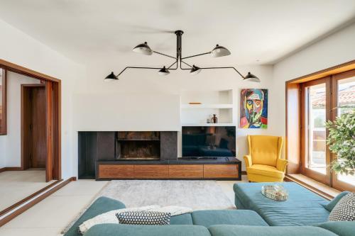 a living room with a blue couch and a fireplace at Beach Villa with Jacuzzi & Garage by HostWise in Vila Chã