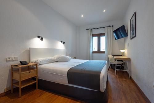 a bedroom with a bed and a desk in it at Los Cantaros in El Puerto de Santa María