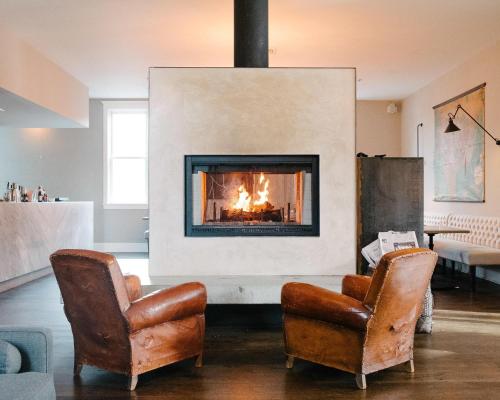 a living room with two chairs and a fireplace at The 200 South St - King Ste 9 in Charlottesville