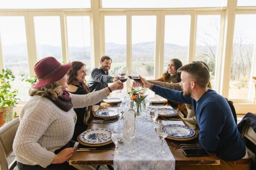 a group of people sitting around a table with wine glasses at The 200 South St - King Ste 9 in Charlottesville