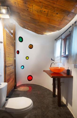 a bathroom with a toilet and a wall with stickers at Kanta Sana in Palomino