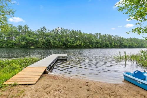 a dock on the shore of a lake with a boat at A Cozy A-Frame Escape with Hot Tub in Oxford