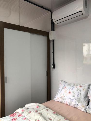 una camera da letto con un letto e una parete bianca di Kitnet Nova e Aconchegante a Cachoeira do Sul
