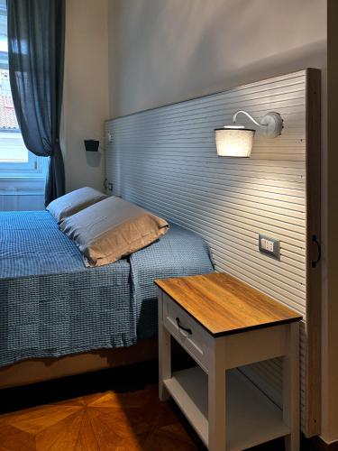 a bedroom with a bed with a wooden headboard and a table at Bed and Chic art rooms in Trieste