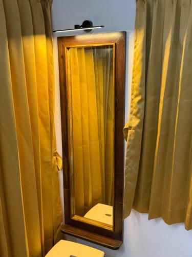 a mirror sitting on a wall next to curtains at OM LINGESWARAN HOME STAY Tiruvannamalai in Tiruvannāmalai