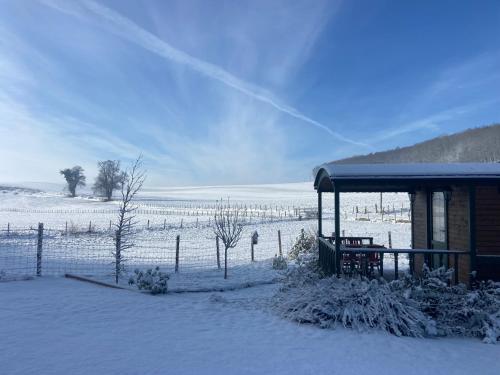 a building with a snow covered field in the background at La roulotte de bonneval in Charleval