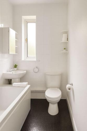 a white bathroom with a toilet and a sink at Bright & Spacious 2 Bedroom Flat in Edinburgh