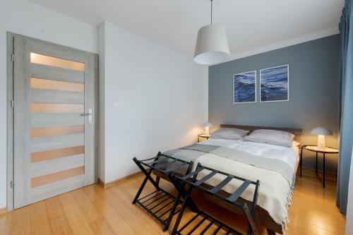 a bedroom with a bed in a room with a door at BATOREGO FLATS No 13 Pszczyna - Walk to Castle - Apartment with Parking, Balcony, Elevator, Fast WiFi in Pszczyna