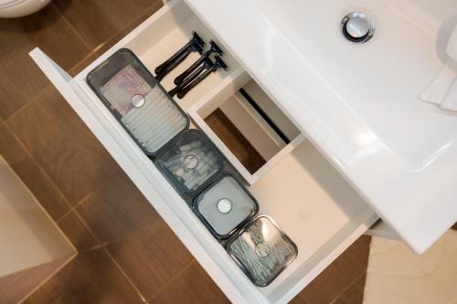 a white bathroom cabinet with two containers on it at BATOREGO FLATS No 13 Pszczyna - Walk to Castle - Apartment with Parking, Balcony, Elevator, Fast WiFi in Pszczyna