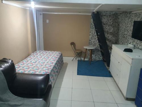 una camera da letto con un letto, una scrivania e una sedia di Apartment a Rio de Janeiro