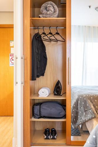 a closet with clothes and shoes in a bedroom at Flat Parque do Ibirapuera - Jardins in Sao Paulo