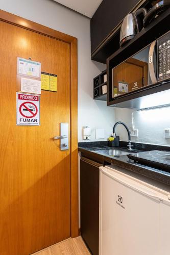 a kitchen with a door with a no smoking sign on it at Flat Parque do Ibirapuera - Jardins in Sao Paulo