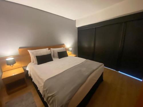 a bedroom with a large bed with two night stands at Flat Parque do Ibirapuera - Jardins in Sao Paulo