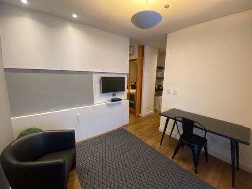 a living room with a table and a chair at Flat Parque do Ibirapuera - Jardins in Sao Paulo