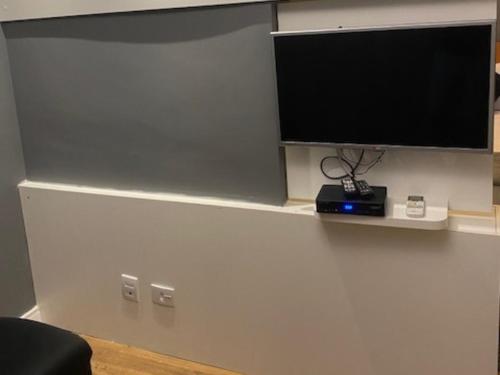 a flat screen tv on a wall with a shelf at Flat Parque do Ibirapuera - Jardins in Sao Paulo