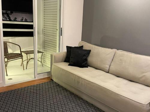 a white couch with a black pillow in a living room at Flat Parque do Ibirapuera - Jardins in Sao Paulo