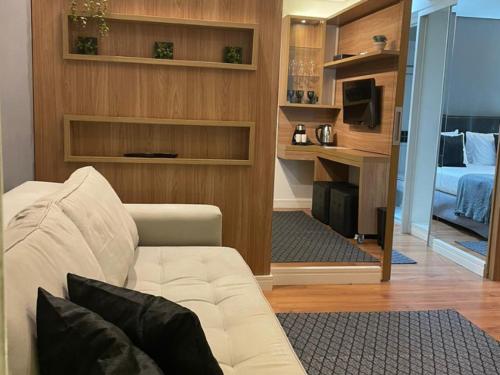 a living room with a white couch and a bed at Flat Parque do Ibirapuera - Jardins in Sao Paulo