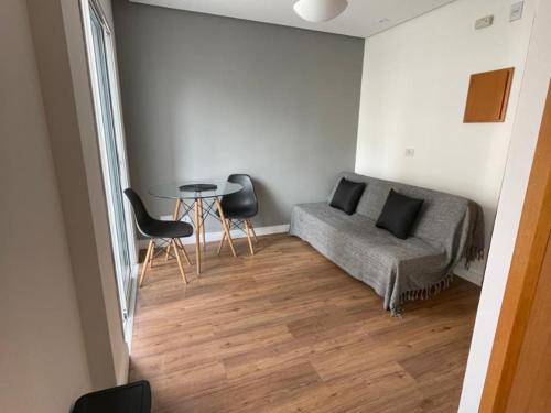 a room with a bed and a table and chairs at Flat Parque do Ibirapuera - Jardins in Sao Paulo