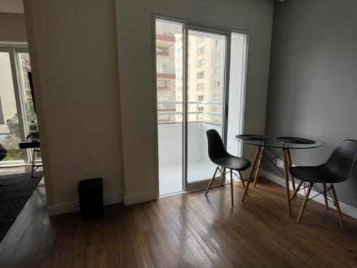 a room with two tables and chairs and a window at Flat Parque do Ibirapuera - Jardins in Sao Paulo