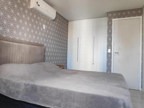 ein Schlafzimmer mit einem großen Bett und einem weißen Schrank in der Unterkunft Flat com piscina em Tambaú in João Pessoa