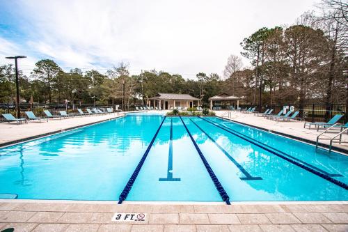 a large swimming pool with blue water and chairs at Bay Club of Sandestin in Destin