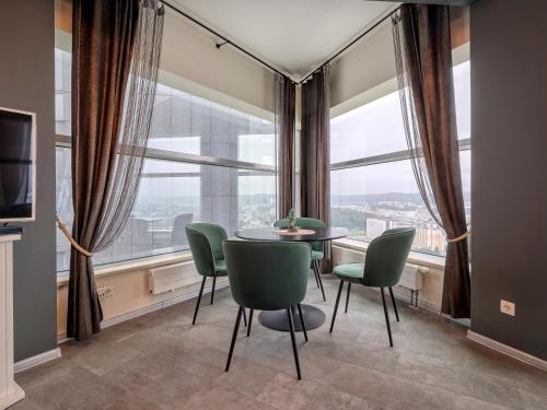 a dining room with a table and chairs in front of a window at SeaTowers 28 TOP FLOOR WATERFRONT PENTHOUSE! Sea & City PANORAMIC VIEW from GLASS CORNER TRIANGLE! 75m2! Terrace! Short&Long Stay! Parking! in Gdynia