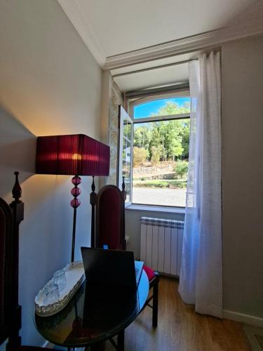 a room with a laptop on a table and a window at Quinta de Marzovelos in Viseu