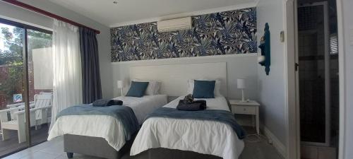 Un dormitorio con dos camas con almohadas azules. en T15SelborneGolfEsatePennington, en Vosburg